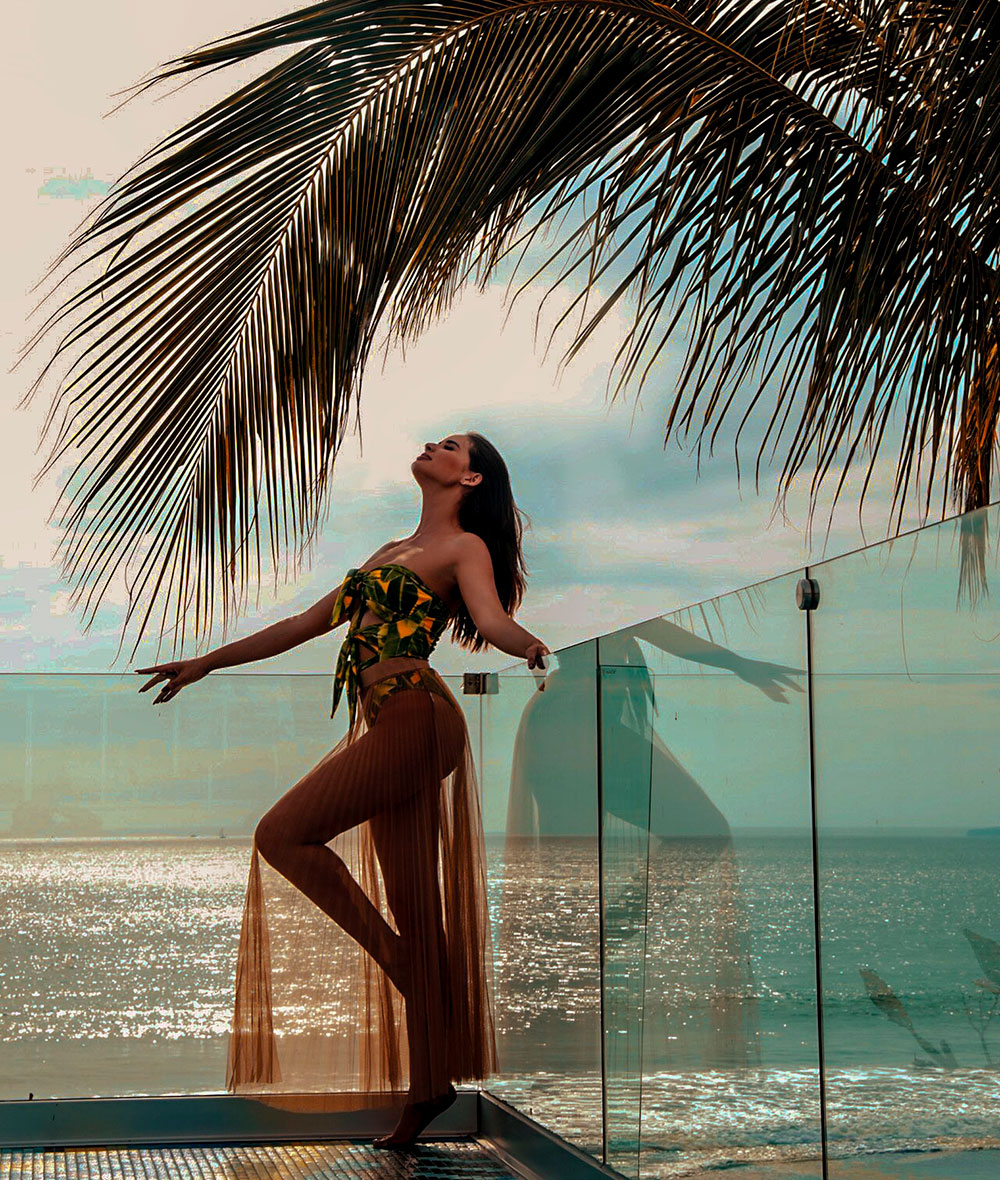 Sheldry Sáez frente al mar bajo una palmera