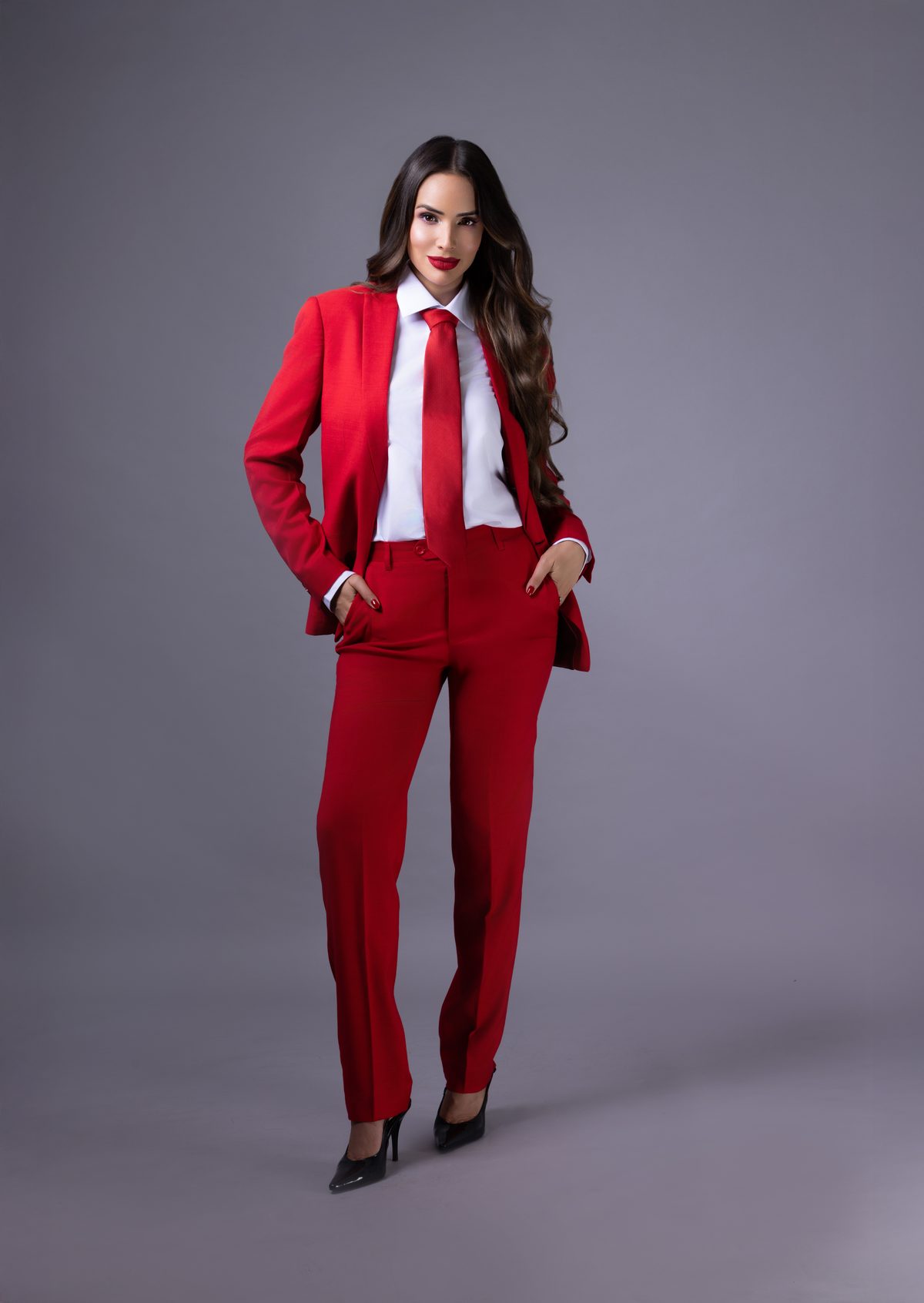 Sheldry Sáez con traje rojo y corbata