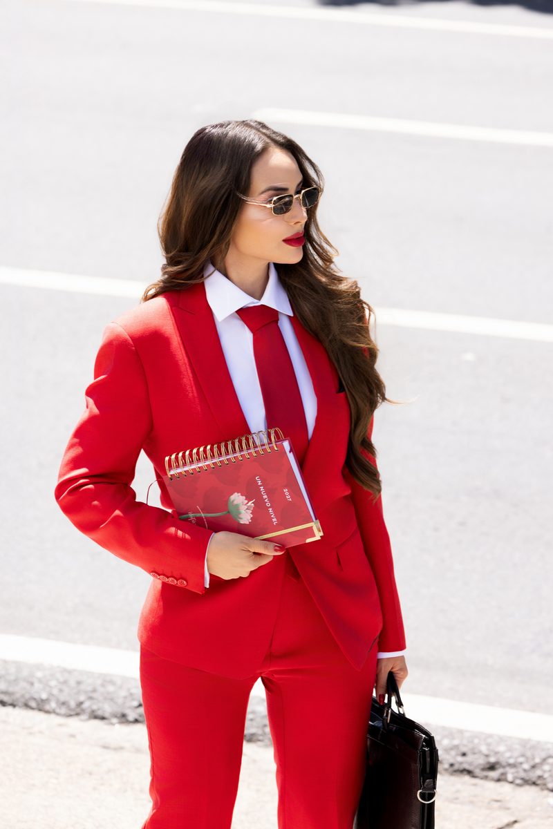 Sheldry Sáez con traje rojo y la Agenda Inspírate 2027 en la calle