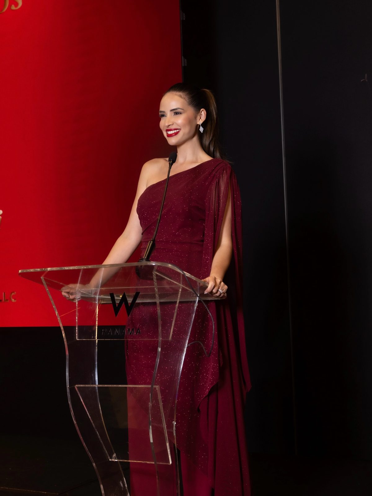 Sheldry Sáez como maestra de ceremonias en el podio de un evento