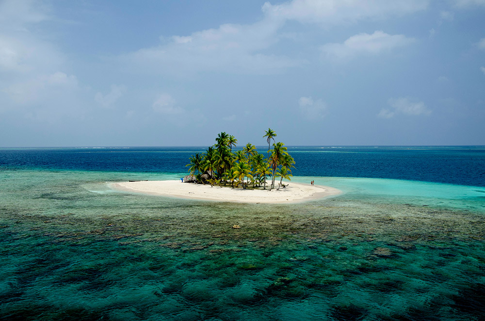 Aerial view of an island in the Guna Yala archipelago surrounded by reefs